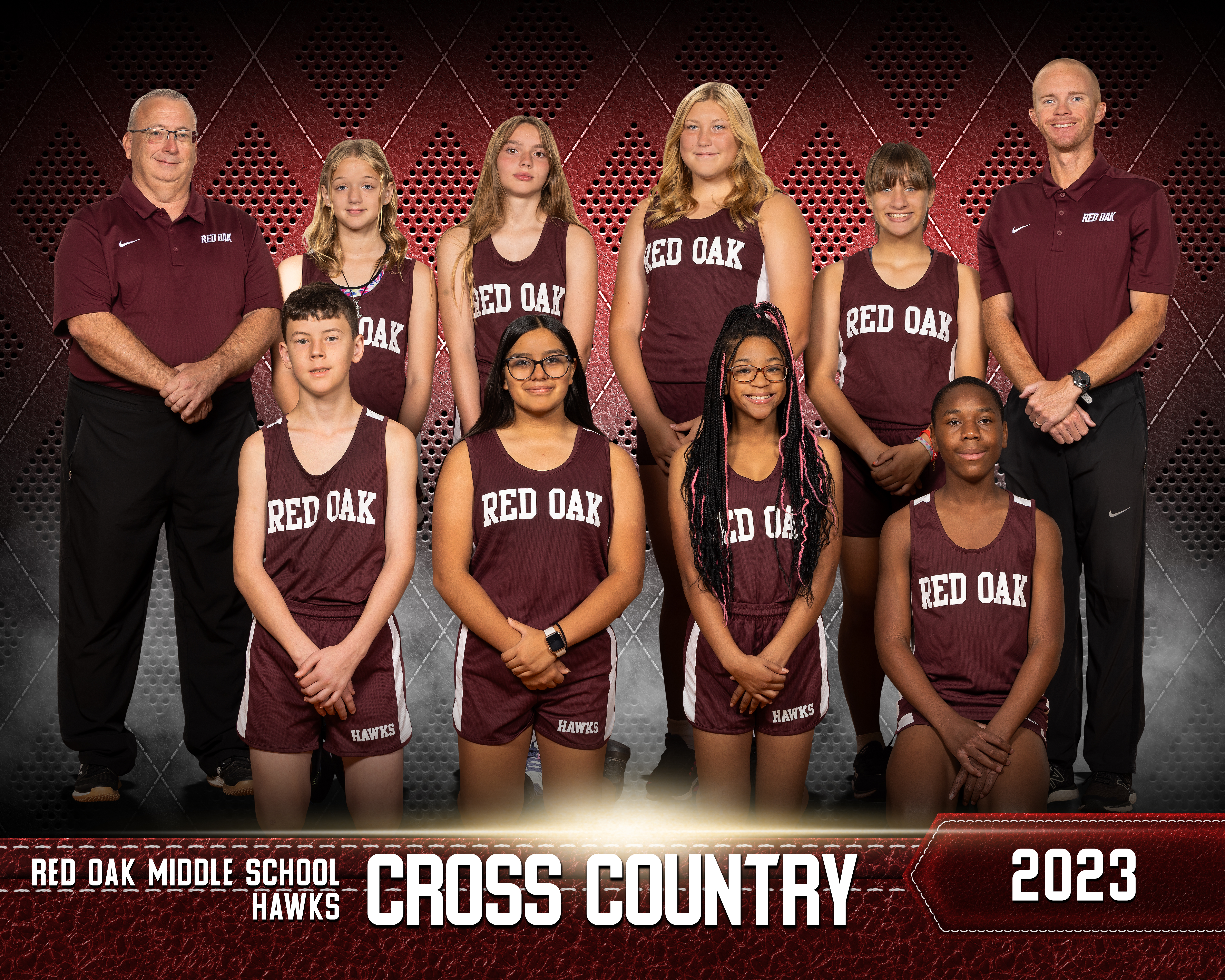 ROMS cross country athletetes posing with their coaches for team picture on football field